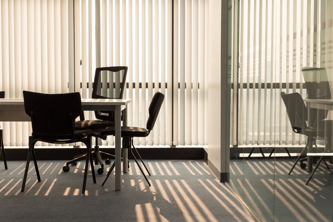 Office Interior With Light Shining Through Window Blinds — Custom Window Furnishings in Wagga Wagga, NSW