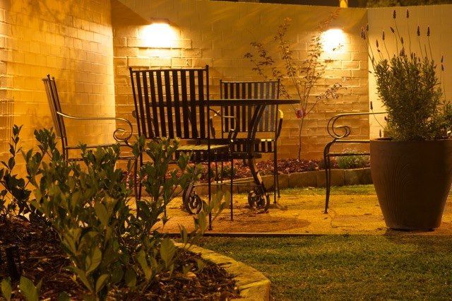 A patio with a table and chairs and a potted plant.