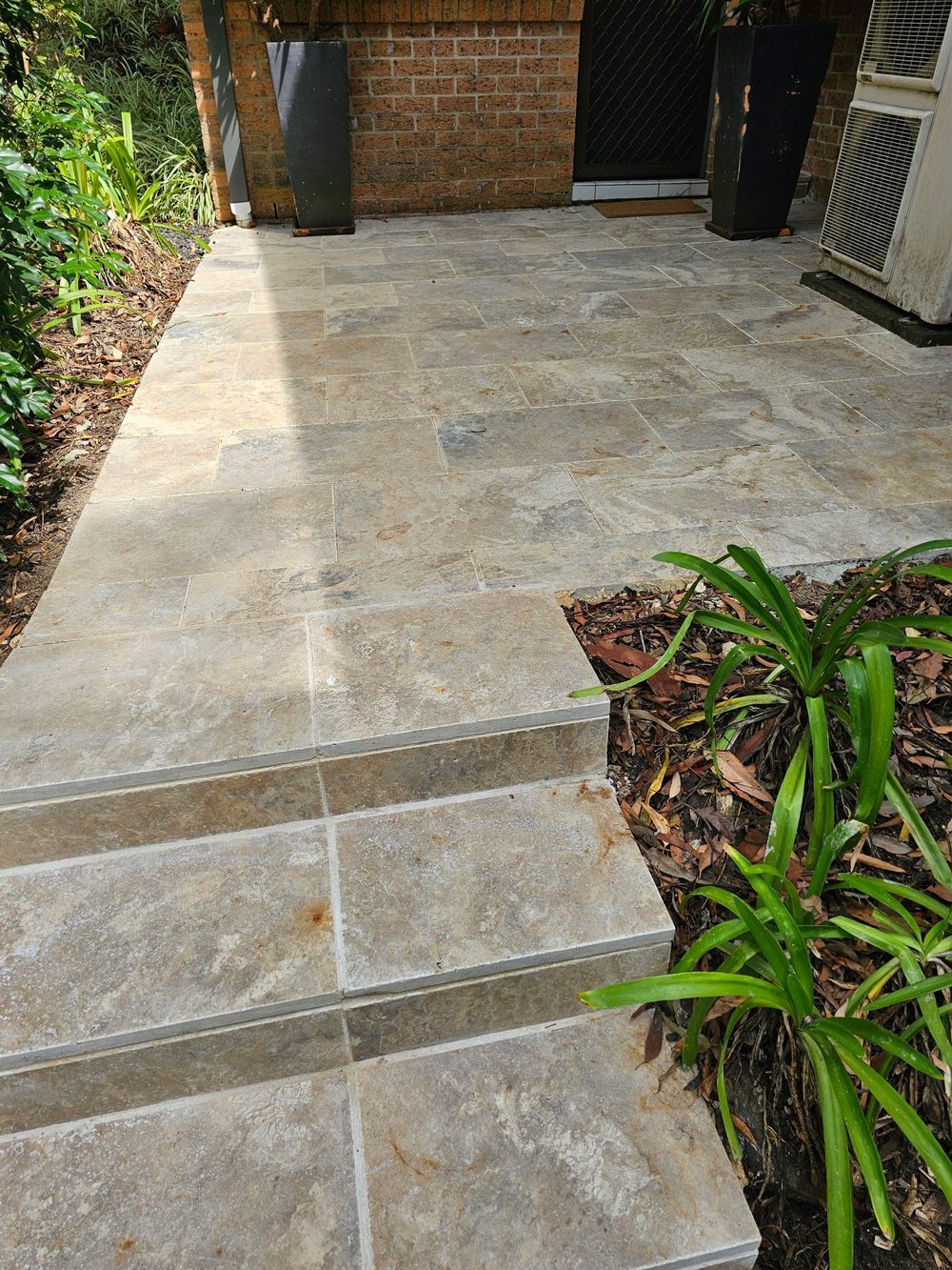 A stone walkway with steps leading up to a brick building.