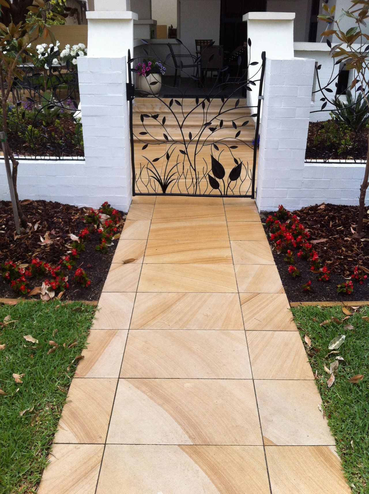 A walkway leading to a gate in front of a house
