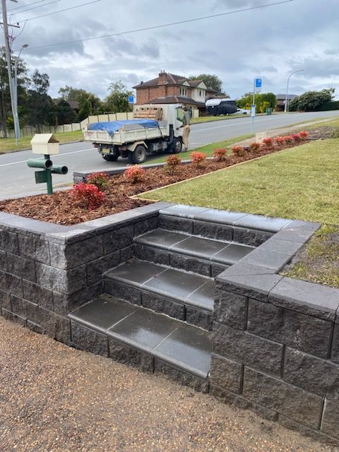 A truck is parked on the side of the road next to a set of stairs.