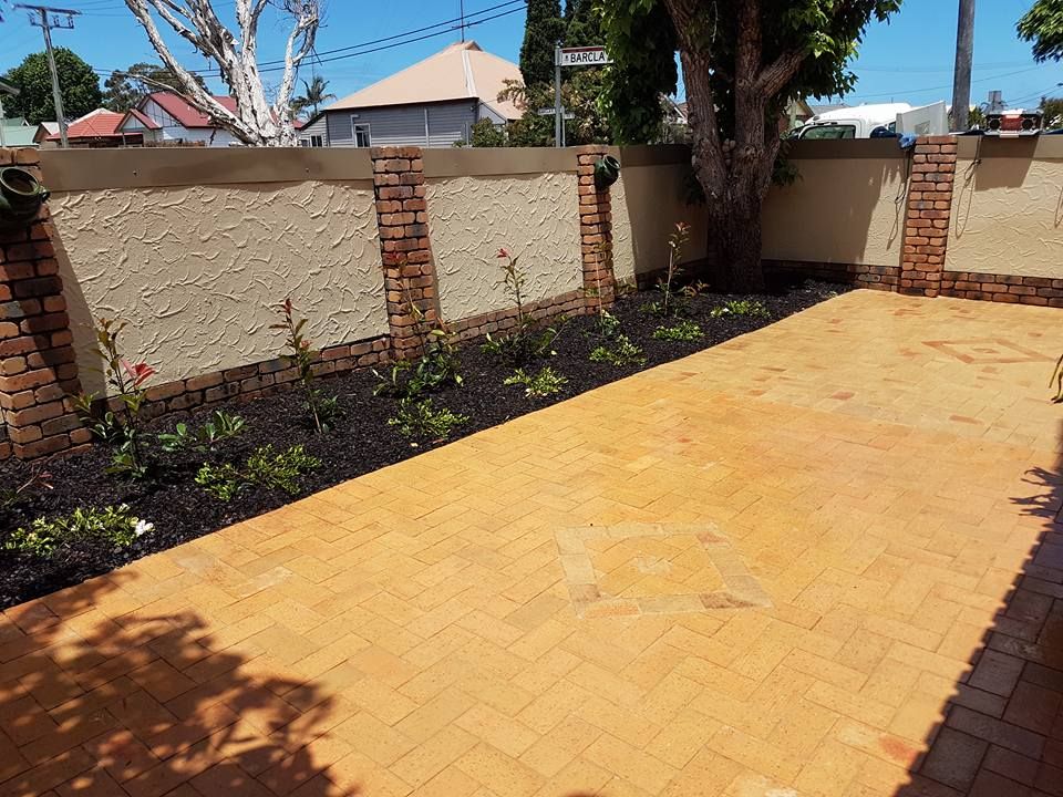 A brick walkway with a tree in the background