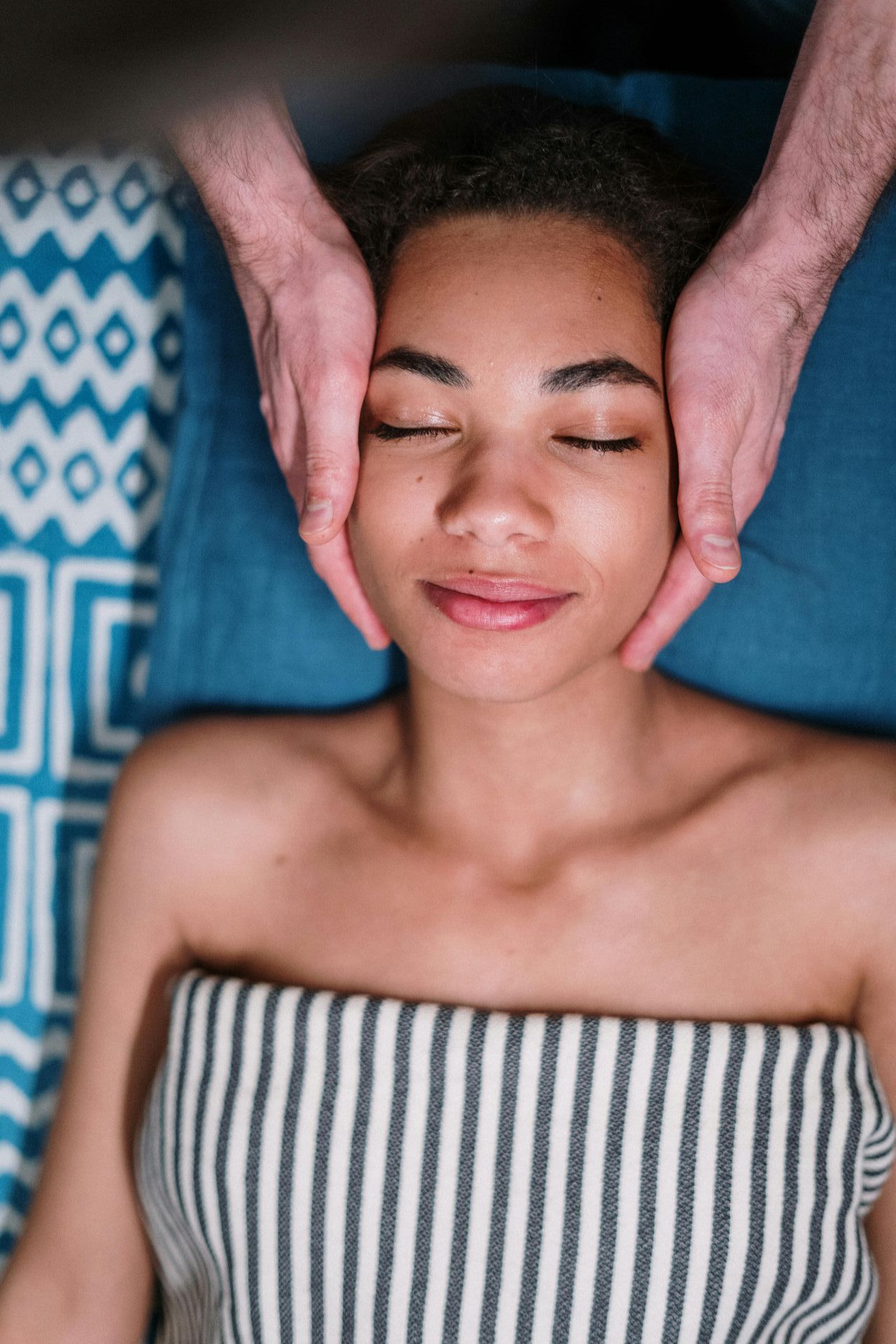 A woman is getting a facial massage at a spa.
