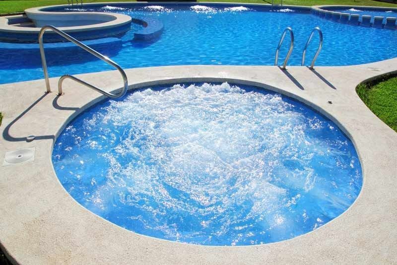 A Swimming Pool With A Jacuzzi In The Middle Of It — Aquatic Pool & Spa Services In Emerald, QLD