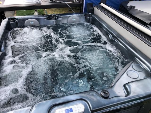 A Hot Tub With Bubbles Coming Out Of It — Aquatic Pool & Spa Services In Yeppoon, QLD