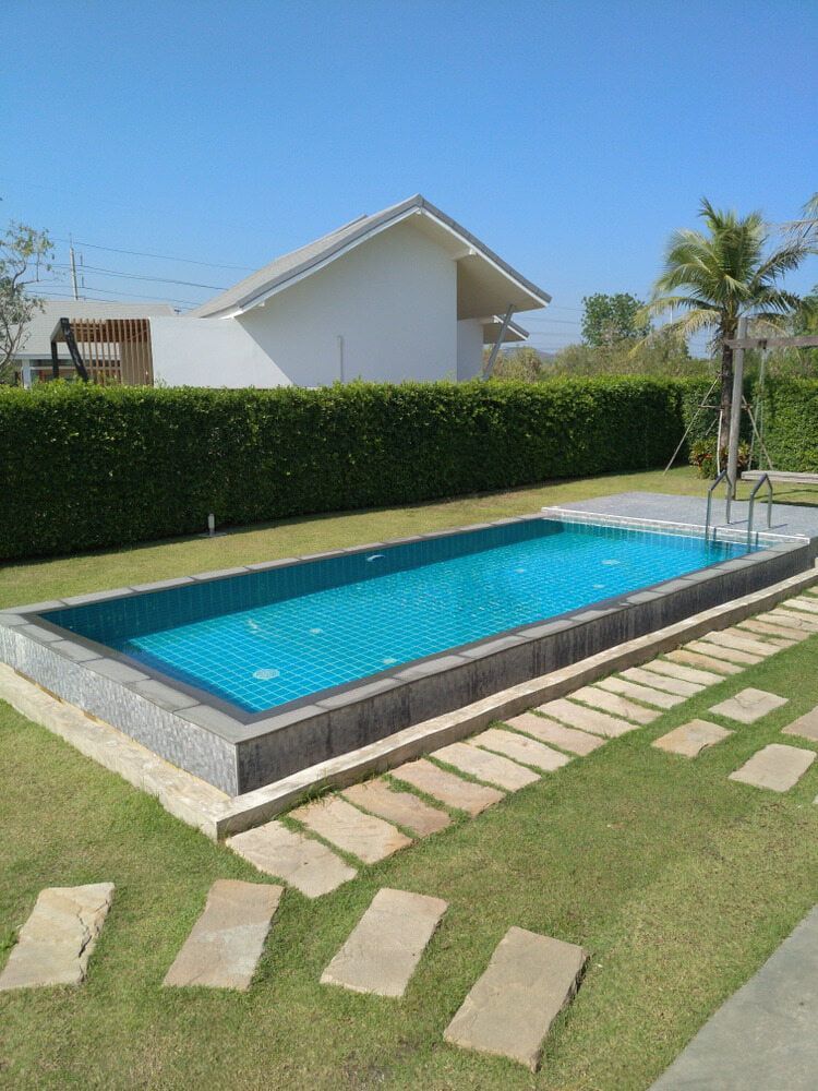 There Is A Large Swimming Pool In The Backyard Of A House — Aquatic Pool & Spa Services In Yeppoon, QLD