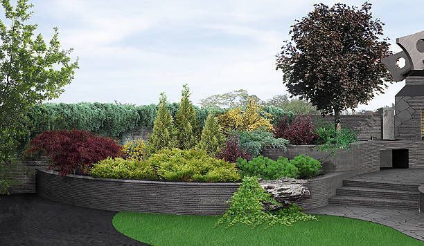 Landscaped garden with tiered colorful plants and a stone retaining wall under a cloudy sky.