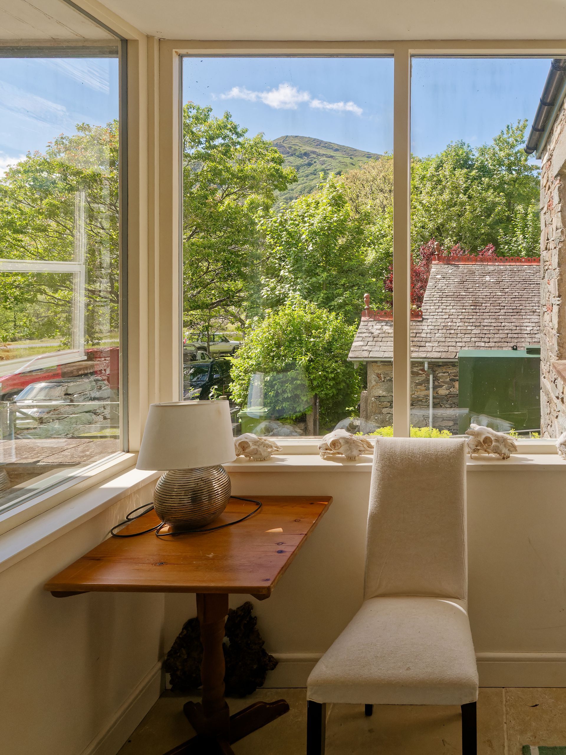 There is a table and chair in front of a large window in the lobby