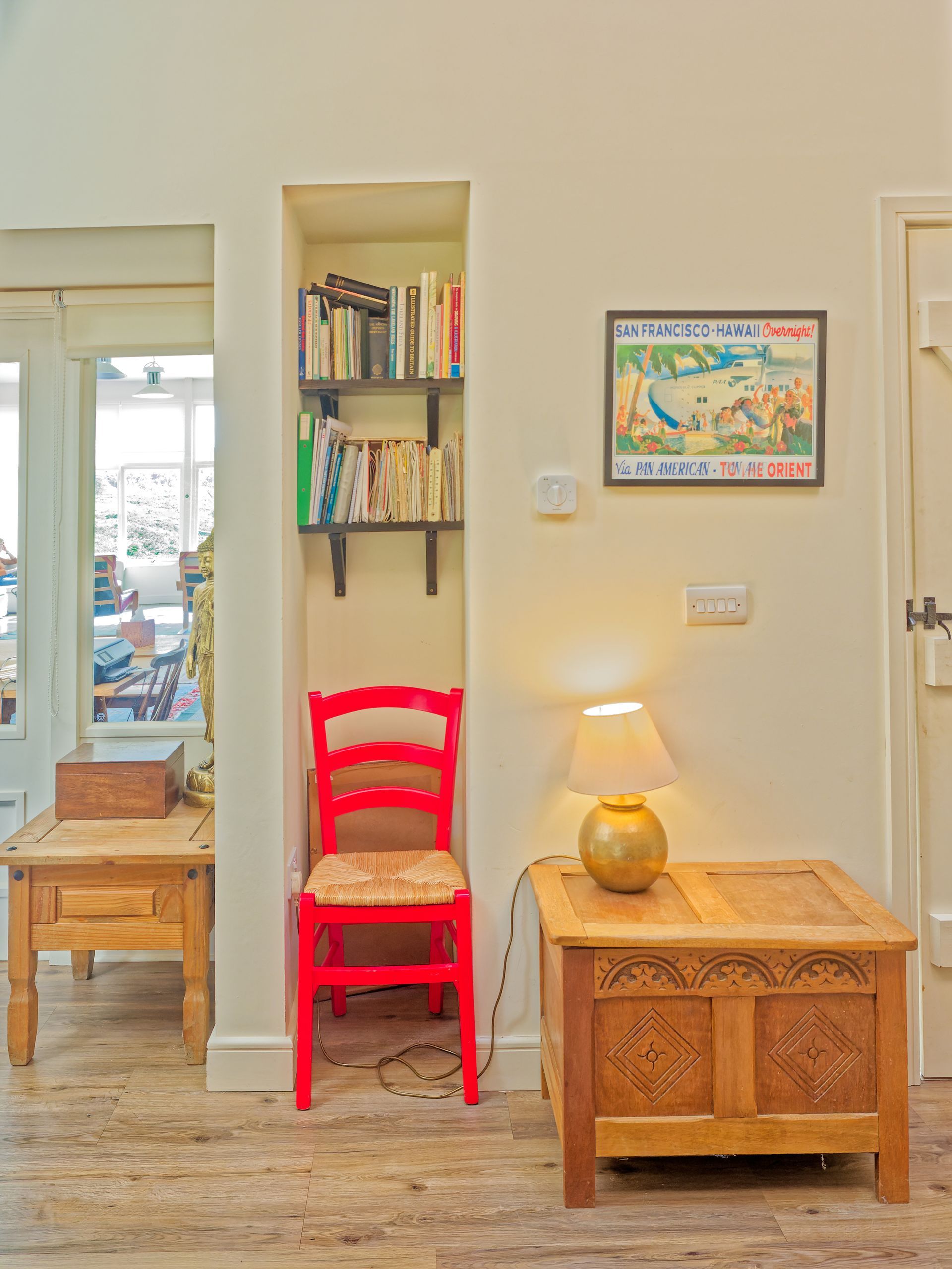 A living room with a red chair and a wooden table