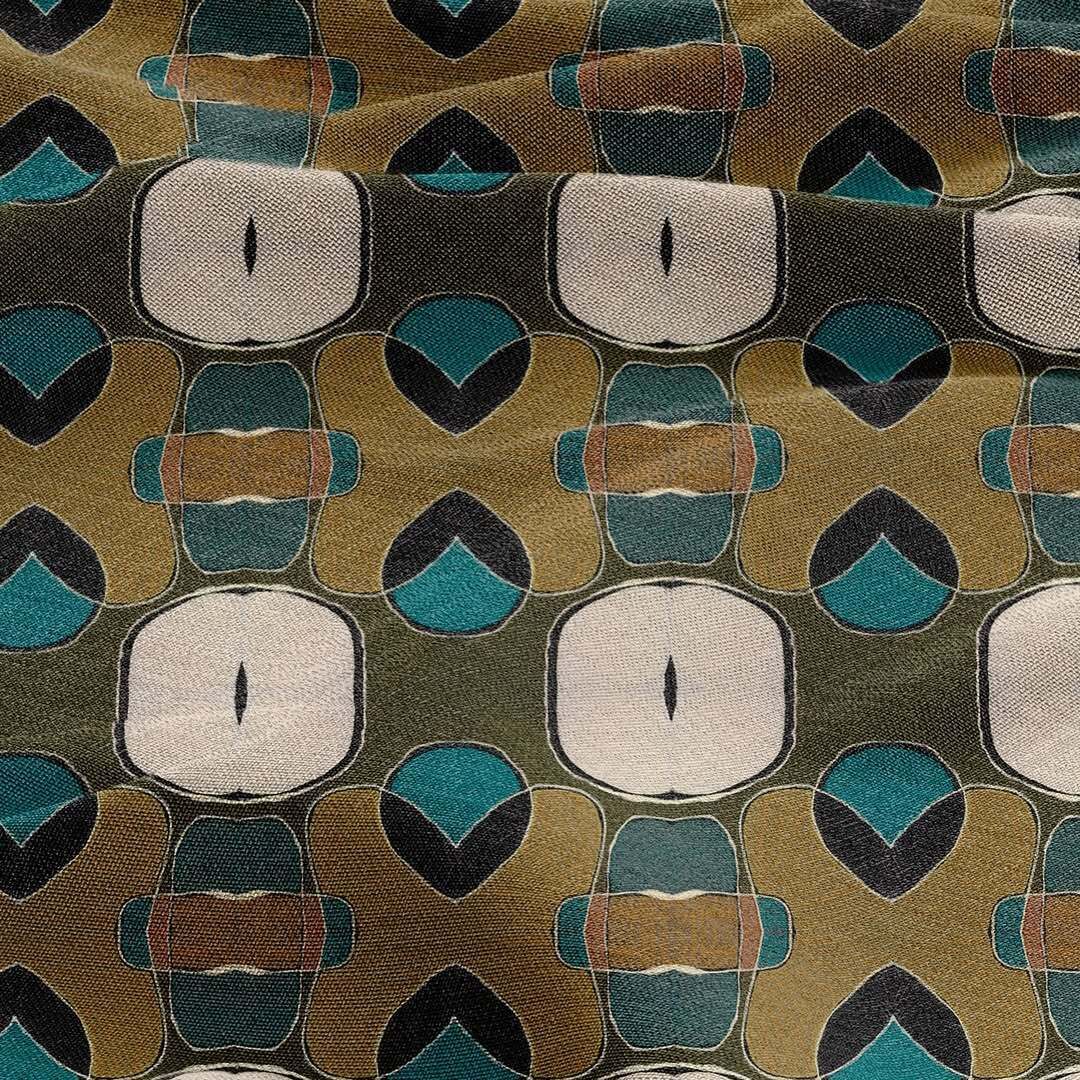 A fabric pattern featuring teal, tan, and cream geometric shapes, including repeating squares and rounded motifs.