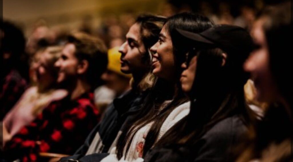 A group of people are sitting in a theater watching a show.