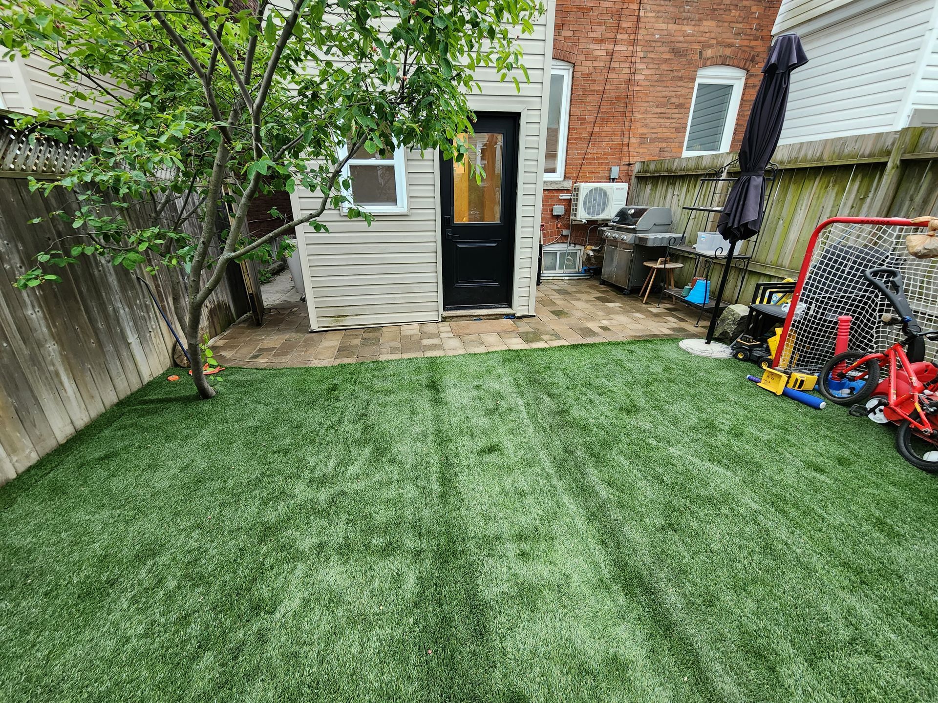 A backyard with a lush green lawn and a house in the background.