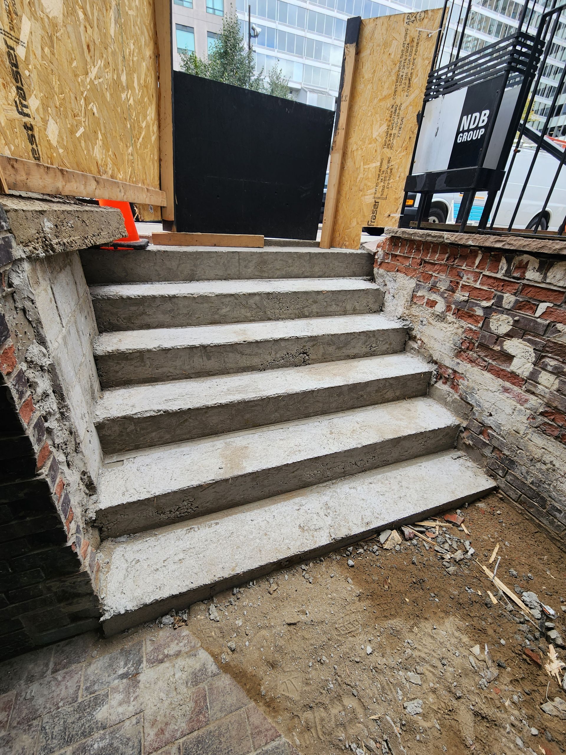 Concrete steps leading up to a construction site opening.