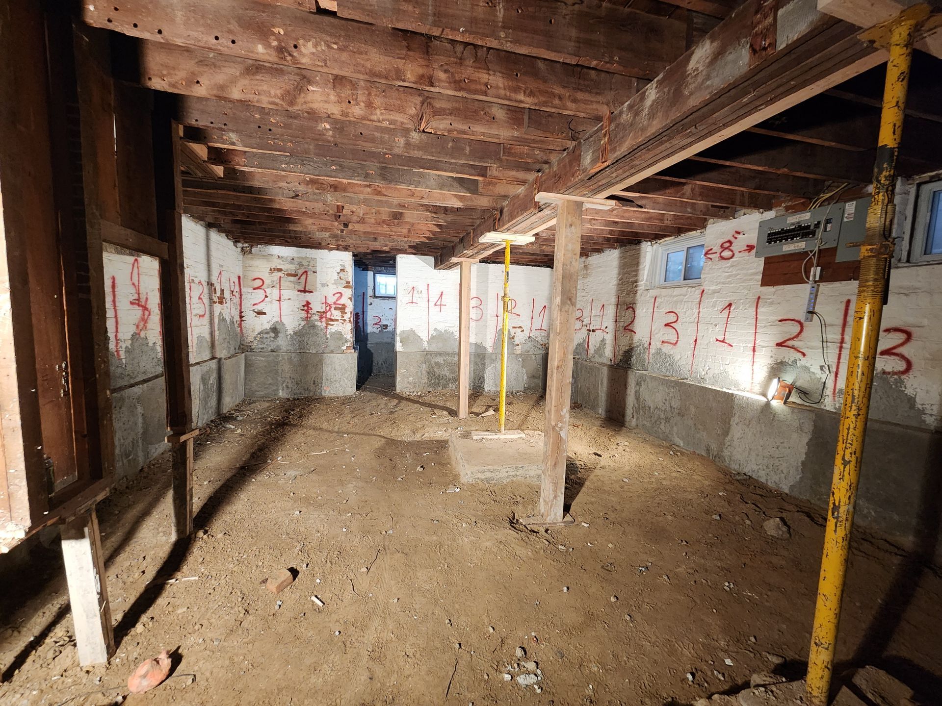 An empty basement with a wooden ceiling and scaffolding.