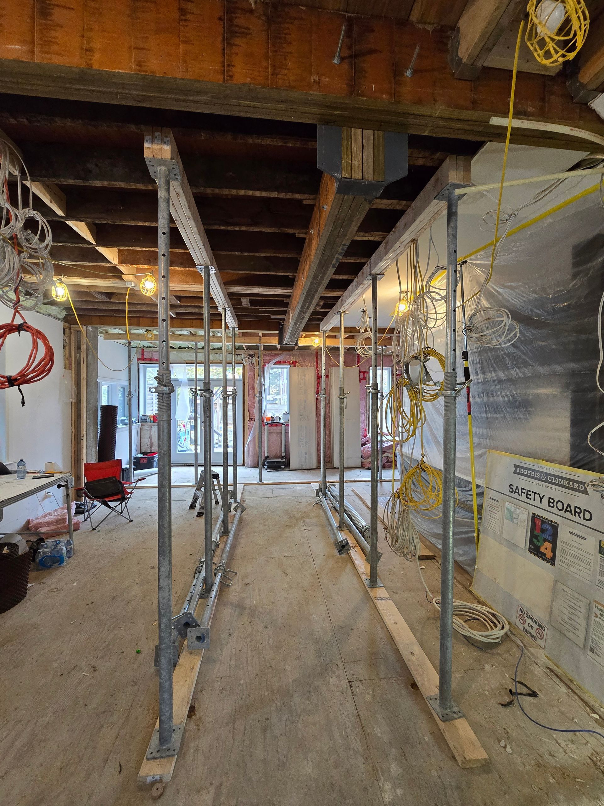 Interior construction site with scaffolding supporting ceiling beams.
