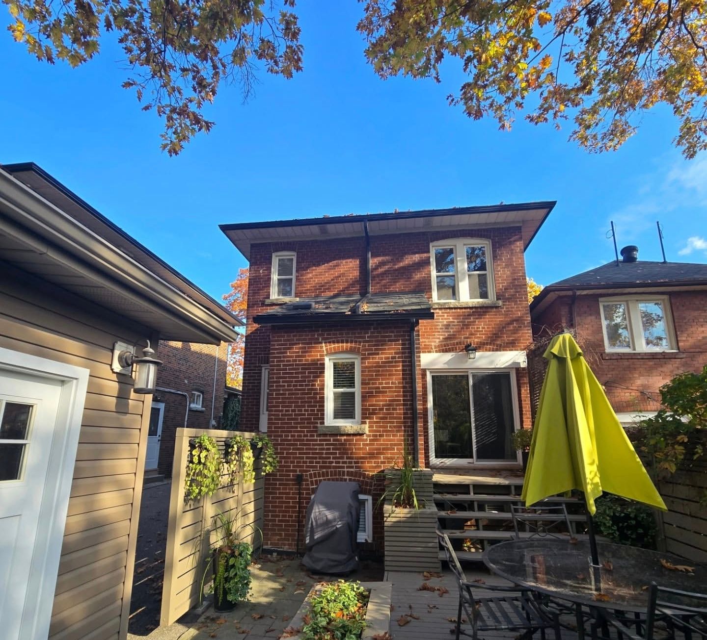 Brick house exterior with a backyard patio on a sunny day.