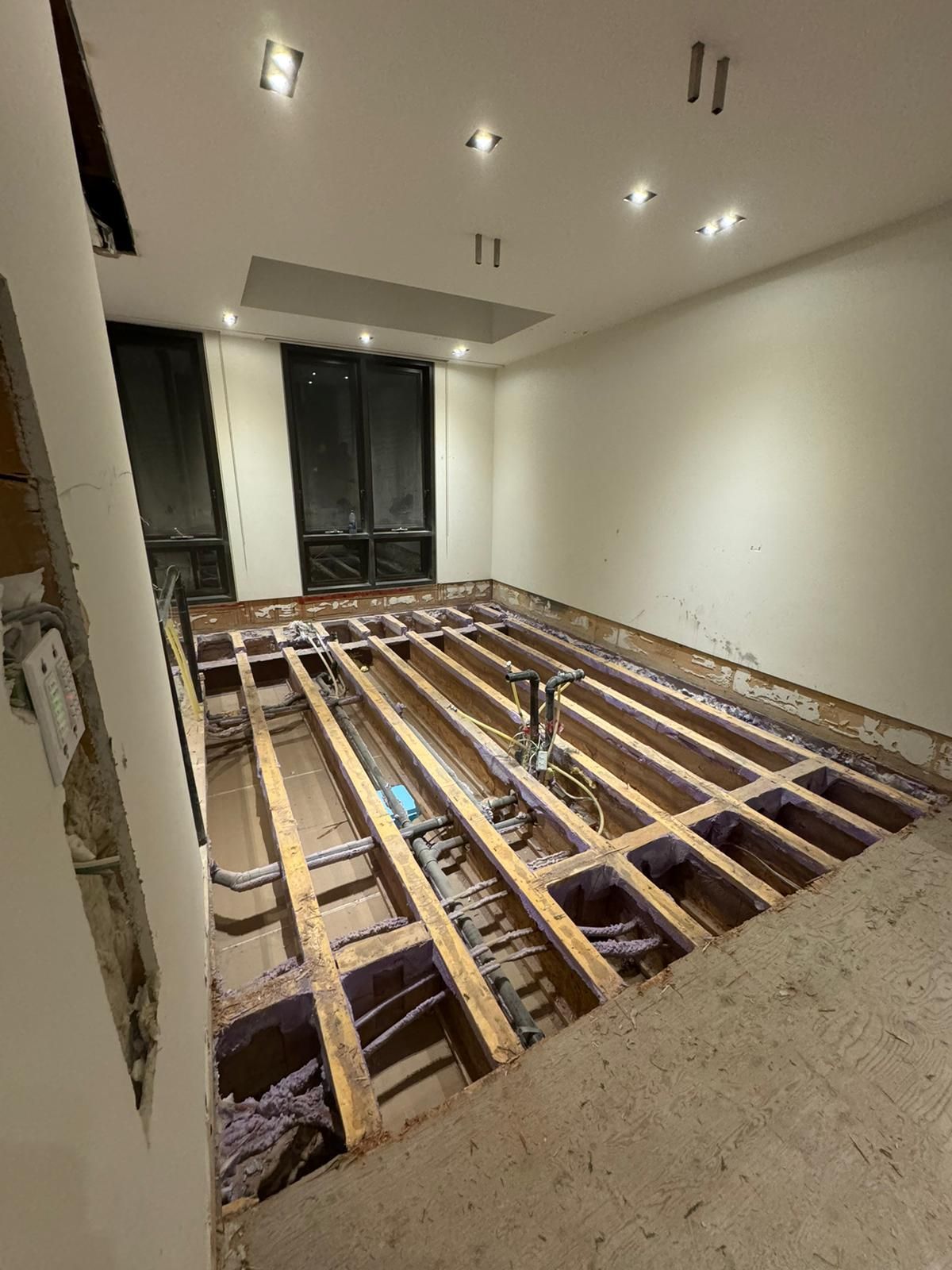 A room with a wooden floor under construction.