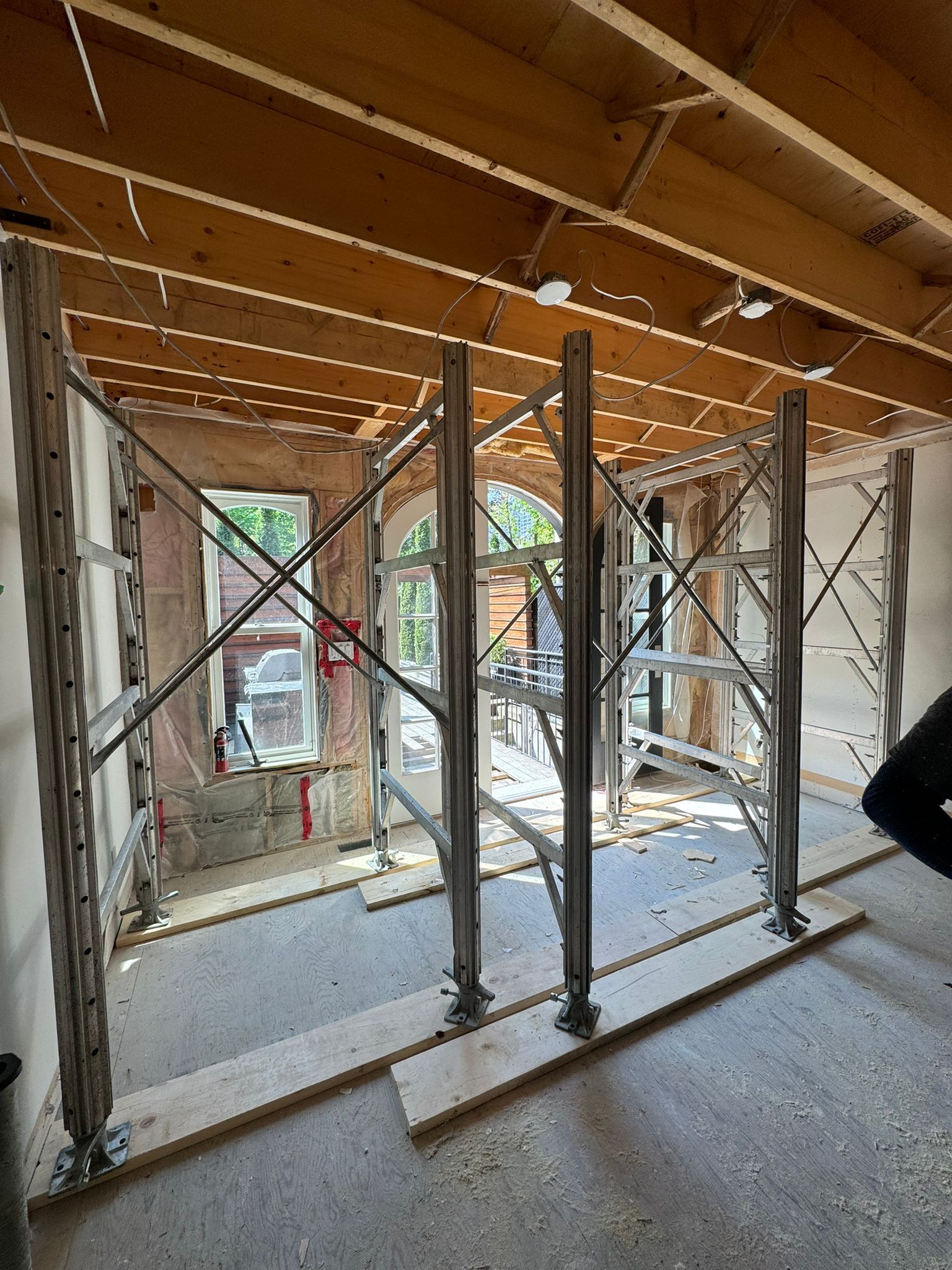 Interior of a room under construction, with support structures in place. Drywall and exposed studs are visible.