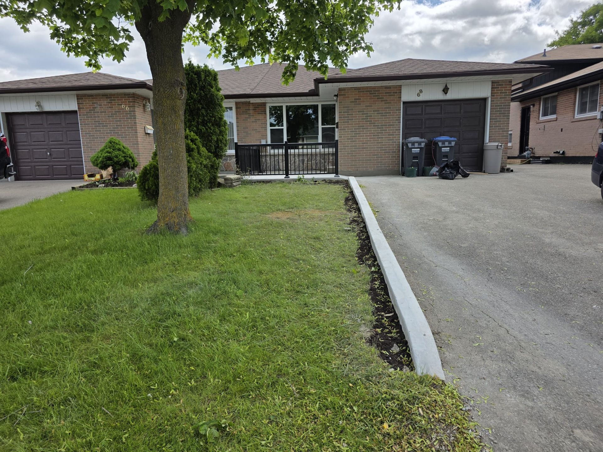 A brick bungalow with a driveway and small front lawn. A tree stands on the left.