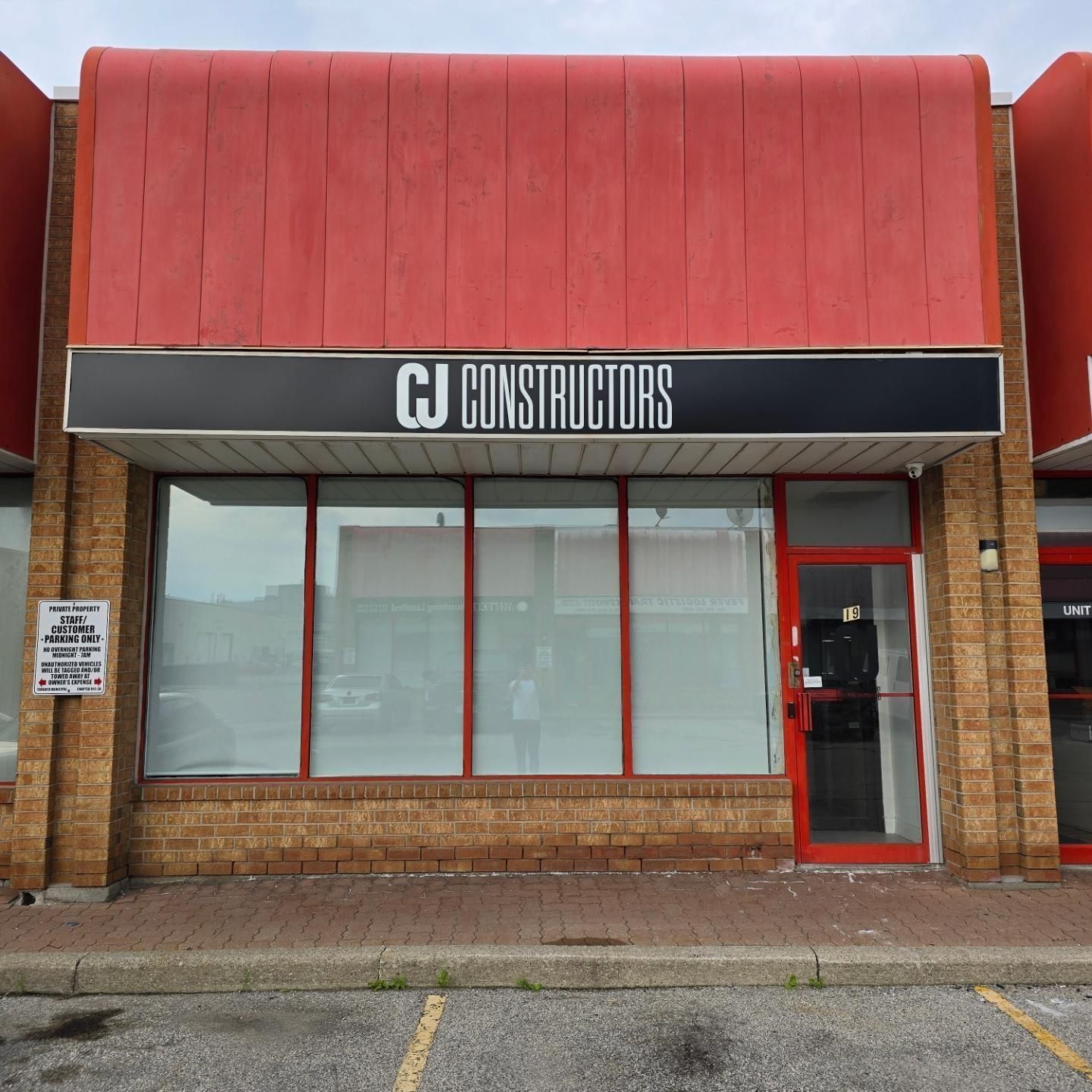 A building with a sign that says ' cj constructors ' on it