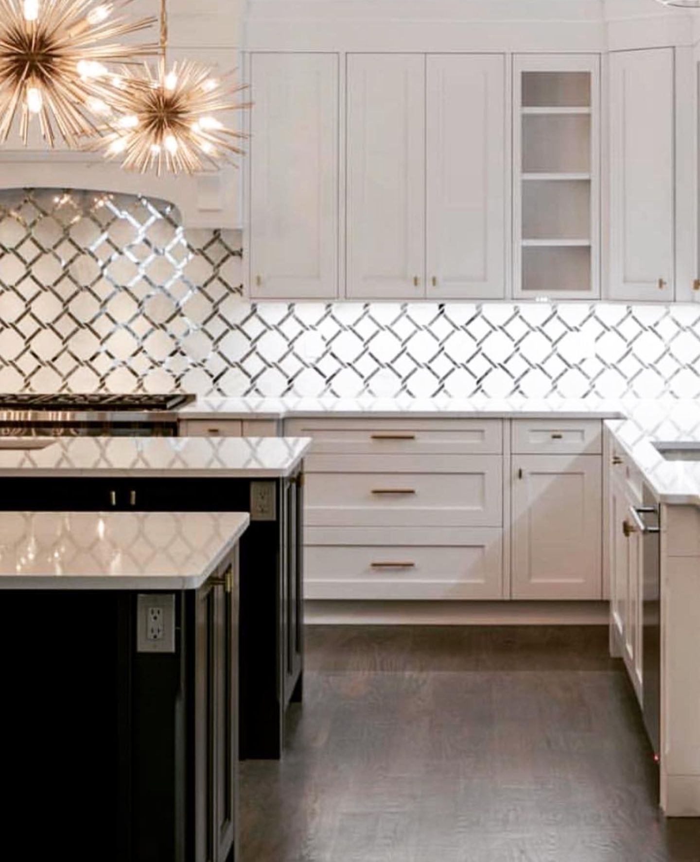 Modern white kitchen with dark wood floors, white cabinetry, a patterned backsplash, and two kitchen islands.