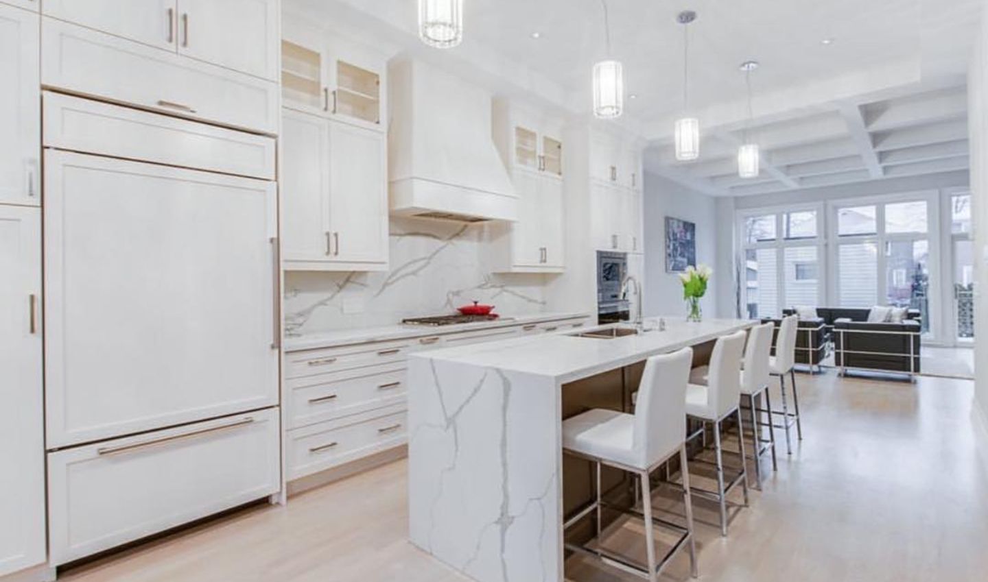 White modern kitchen with island, cabinets, and dining area.