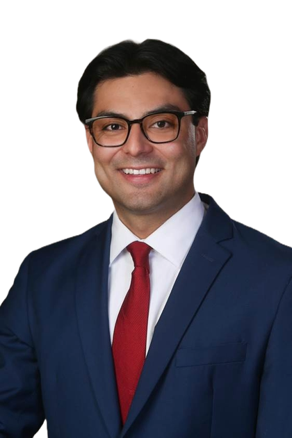 A man in a suit and tie is standing with his arms crossed.