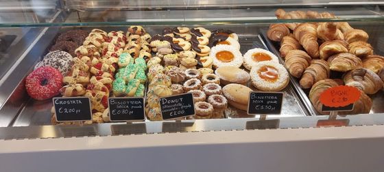 Una vetrina piena di pasticcini e ciambelle di vario tipo.