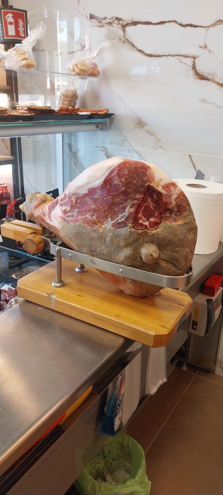 Un grosso pezzo di carne è appoggiato su un tagliere di legno.