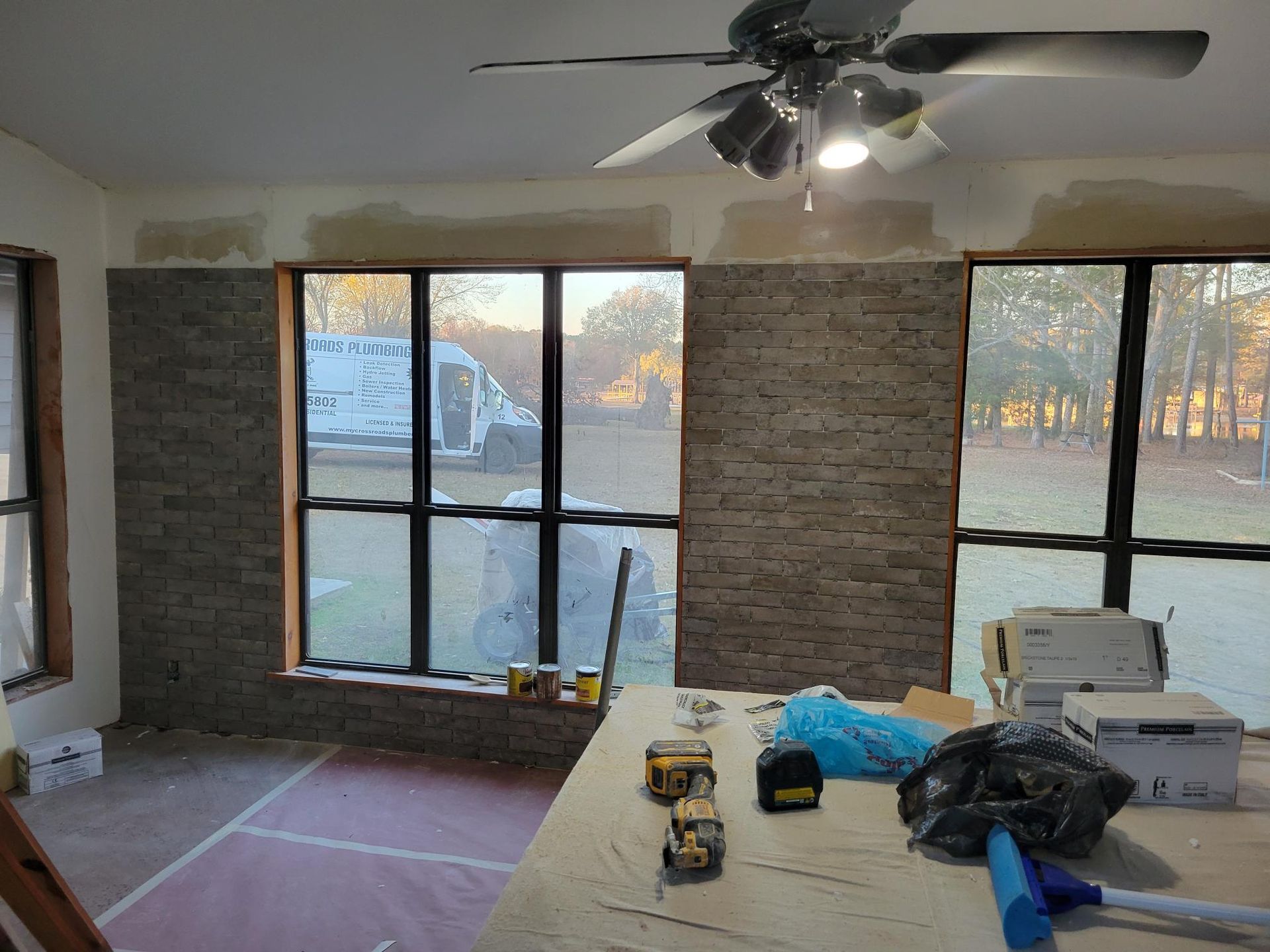 A room with a ceiling fan and a table with tools on it.