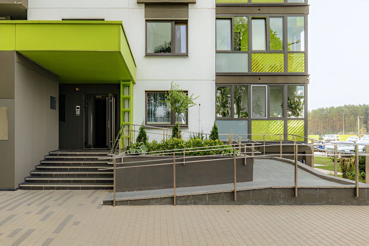 A building with a green awning and stairs leading up to it.