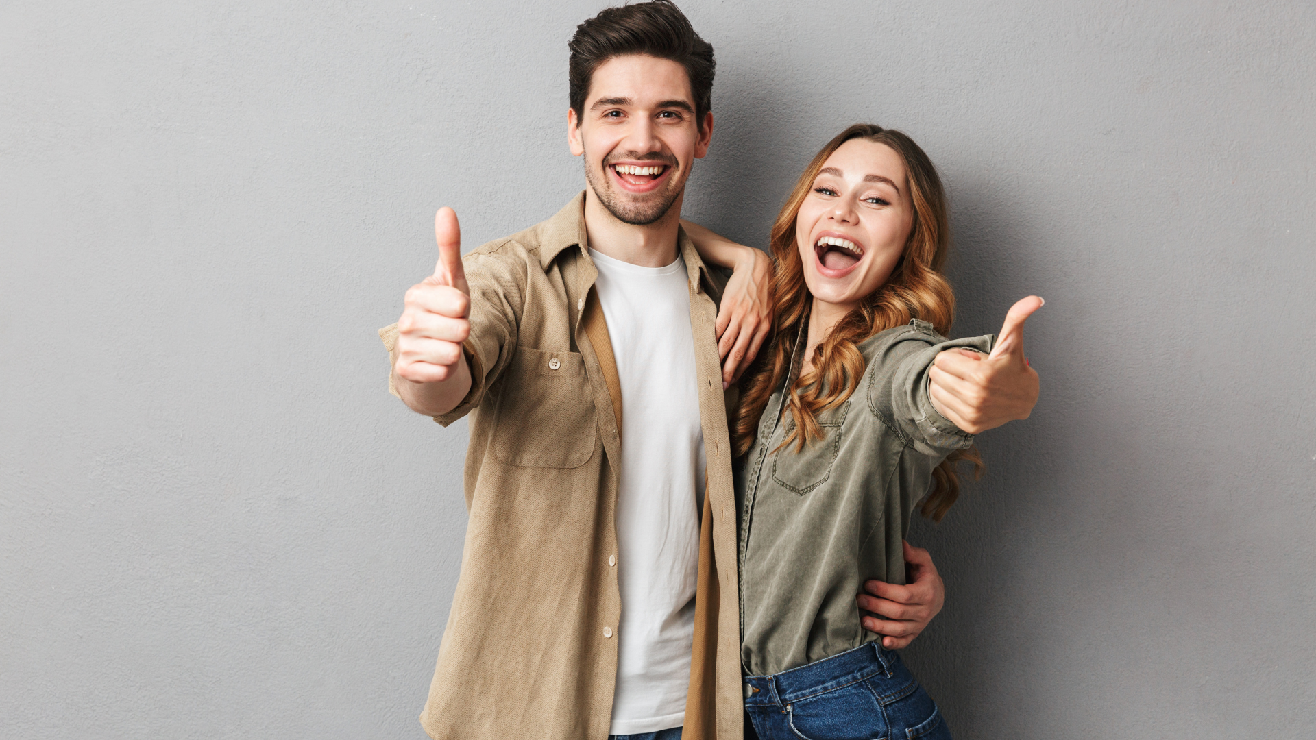 A man and a woman are giving a thumbs up sign.