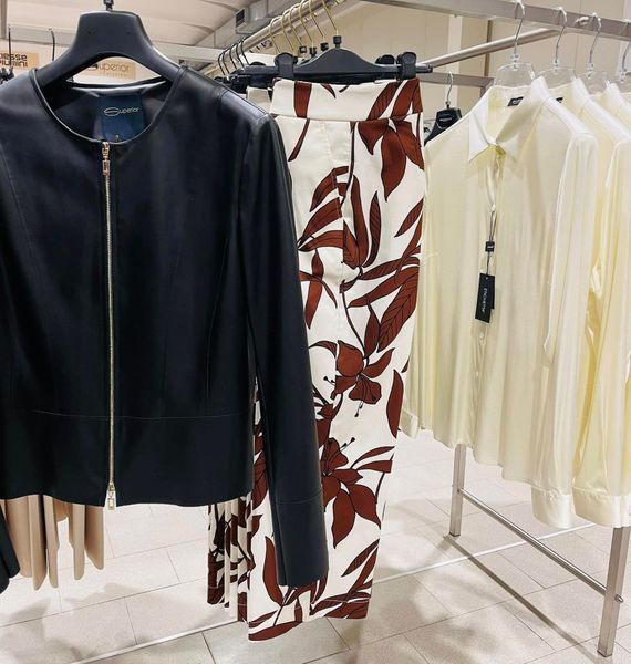 Appendiabiti con giacca nera, pantaloni a fiori e camicie color crema.