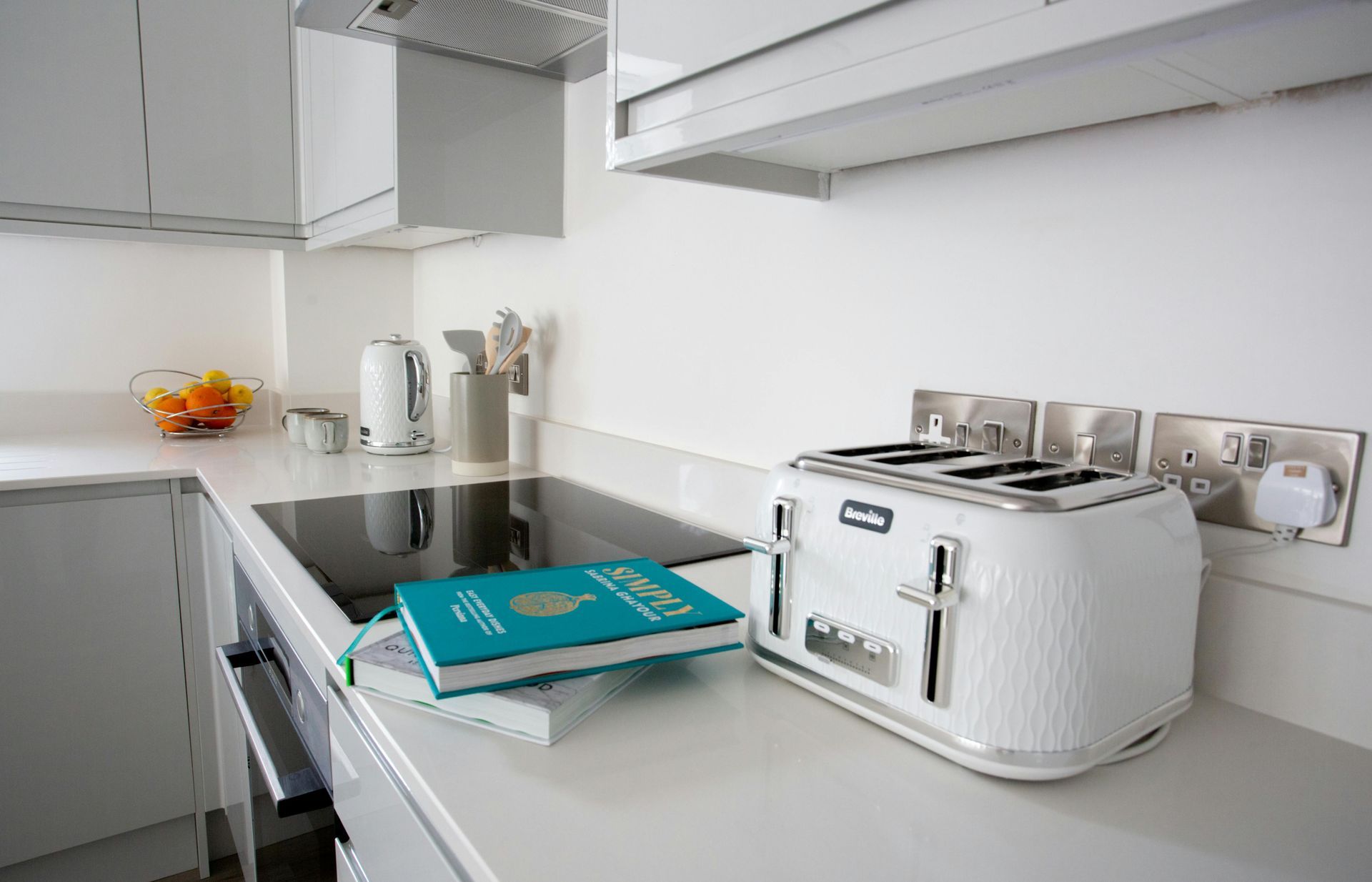 A kitchen with a toaster and a book on the counter.