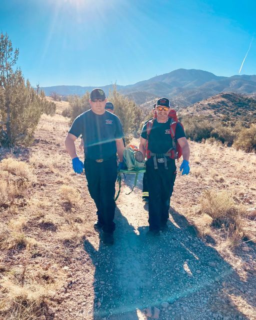 VVFD Firefighters wheel a patient off a hillside on a stretcher