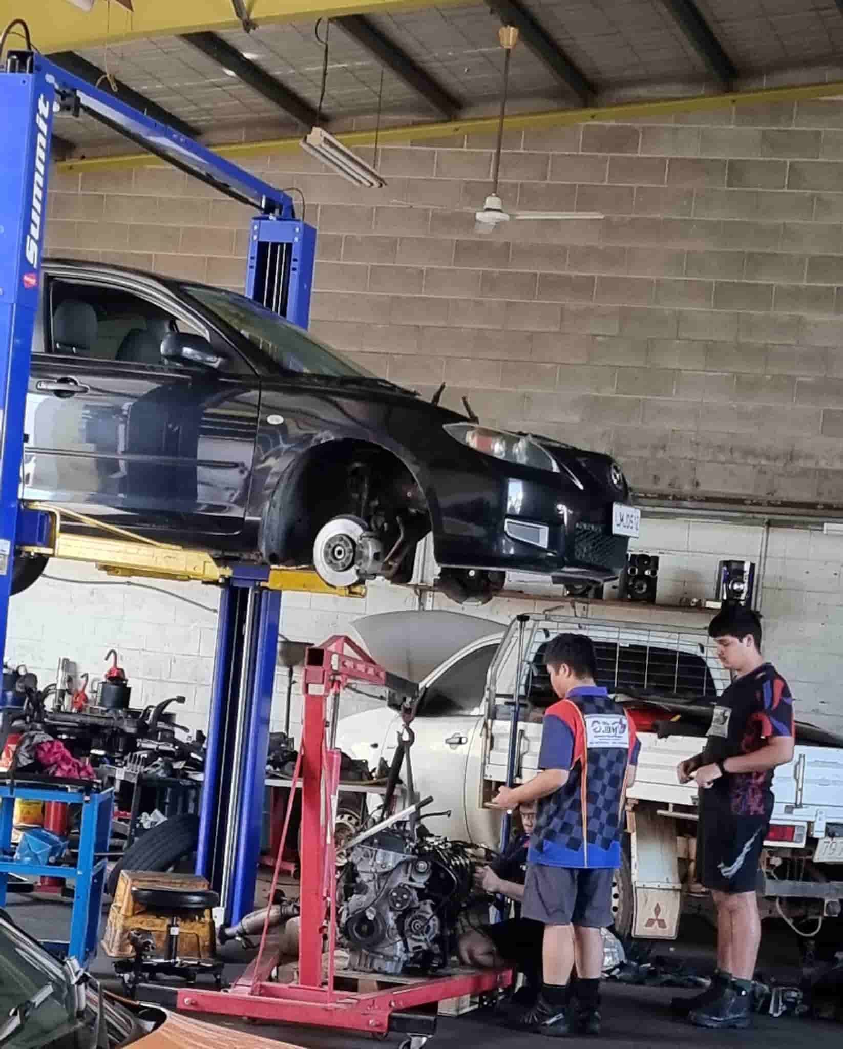A Group of Men Are Working on a Car in a Garage — JDM Mechanical & Aircon Repairs In Coconut Grove, NT