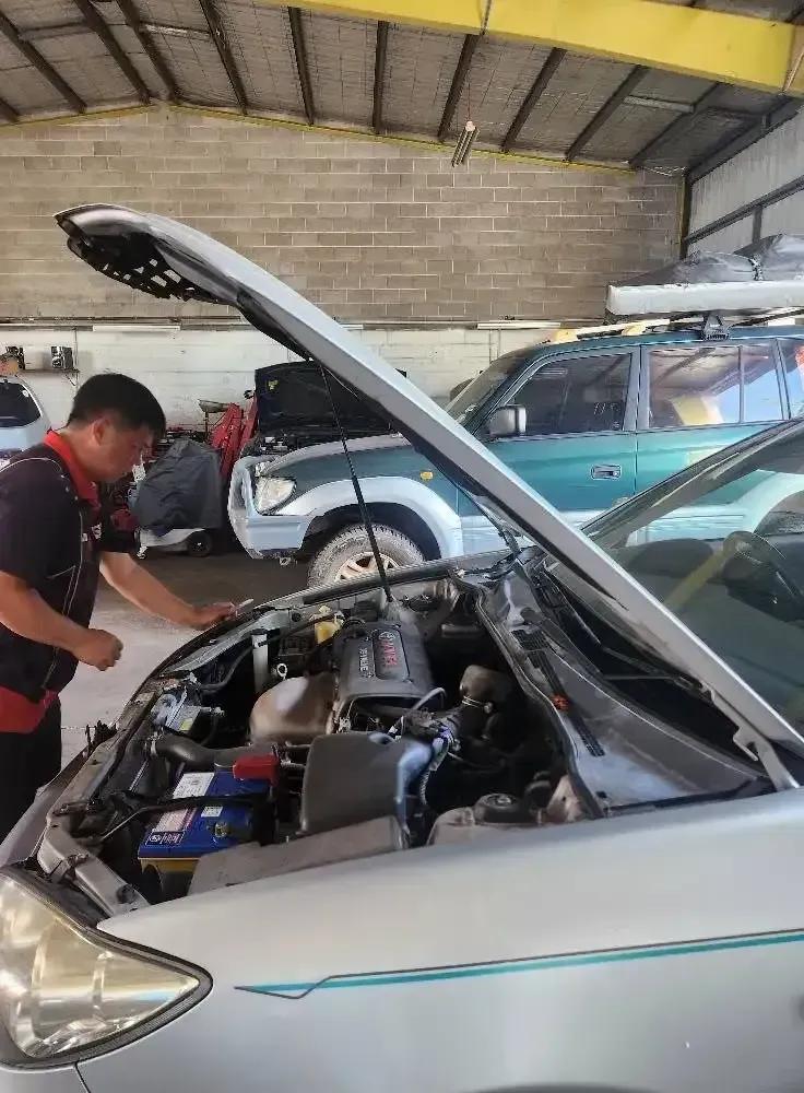A Man is Working on the Engine of a Car in a Garage — JDM Mechanical & Aircon Repairs In Coconut Grove, NT