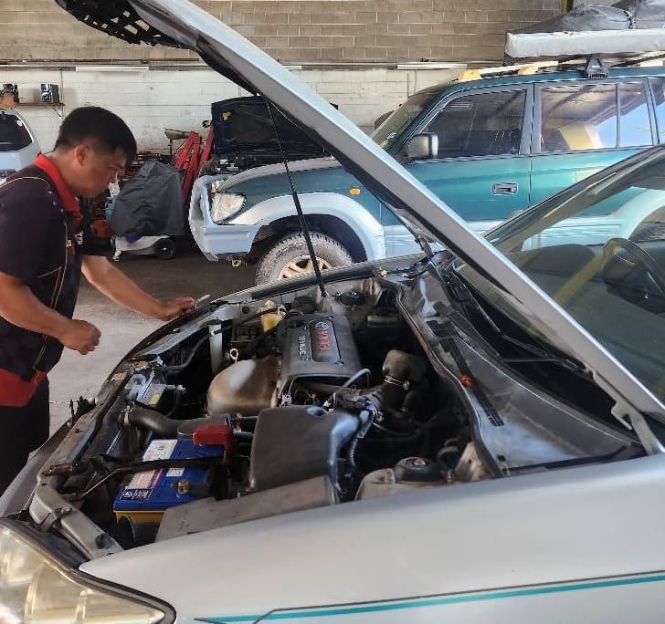 A Man is Looking Under the Hood of a Car — JDM Mechanical & Aircon Repairs In Coconut Grove, NT