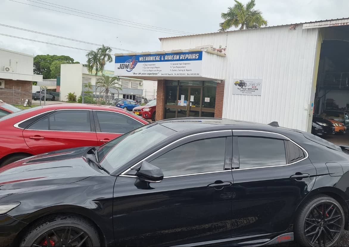 A Black Car is Parked in Front of a White Building — JDM Mechanical & Aircon Repairs In Coconut Grove, NT