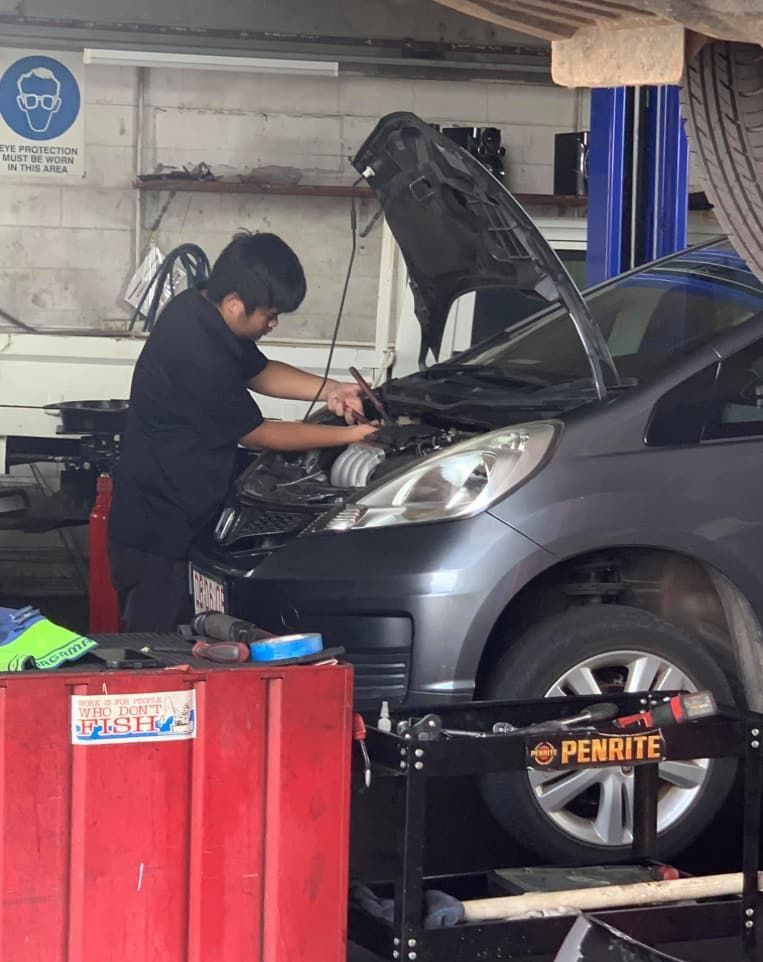 A Man is Working on a Car in a Garage With the Hood Open — JDM Mechanical & Aircon Repairs In Coconut Grove, NT