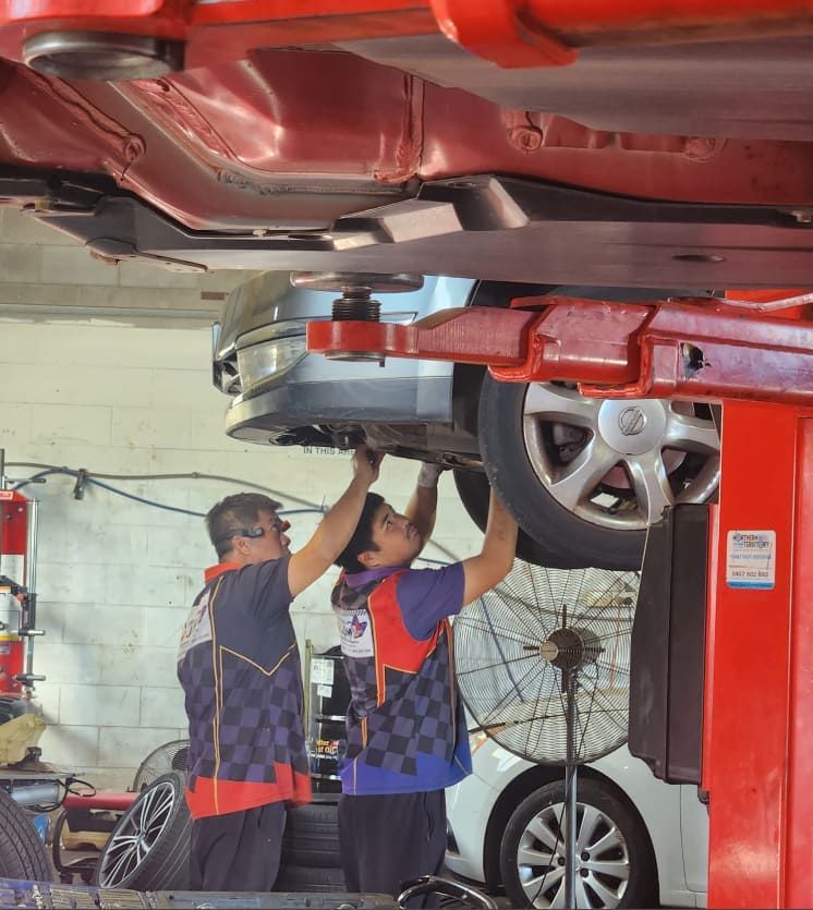 Two Men Are Working Under a Car on a Lift — JDM Mechanical & Aircon Repairs In Coconut Grove, NT