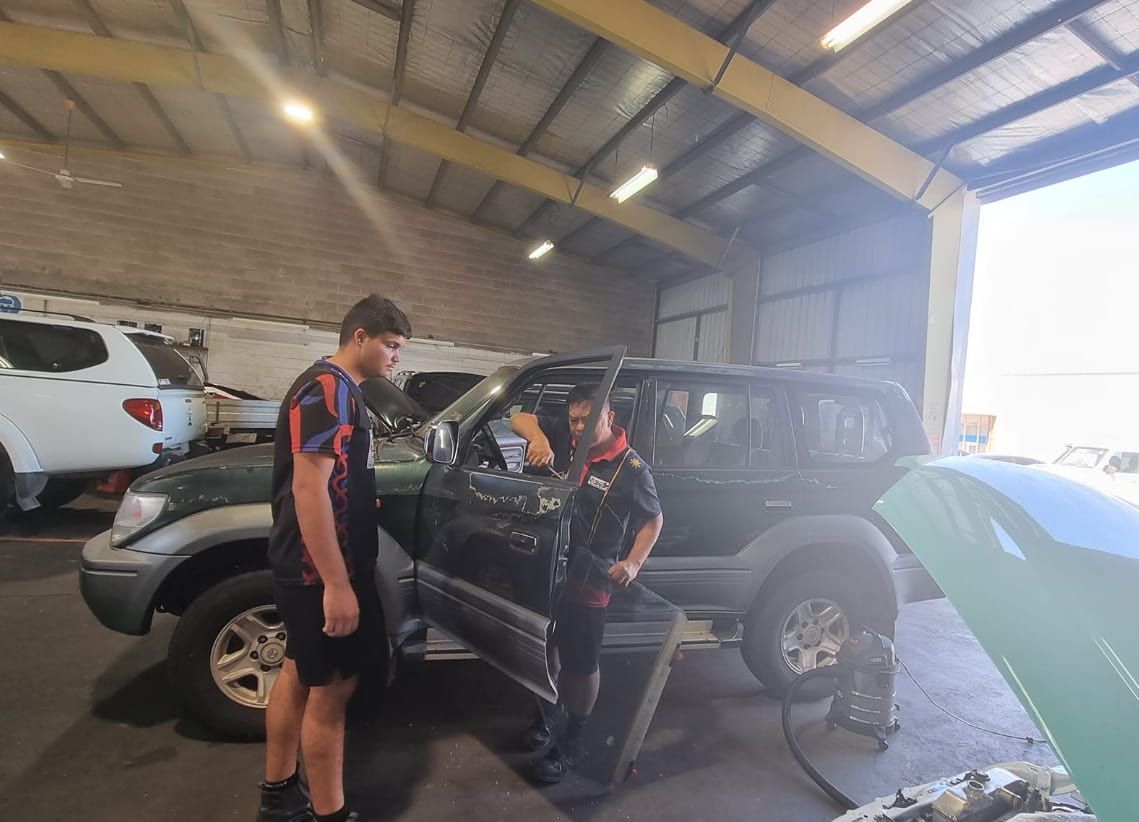 Two Men Are Standing Next to a Car in a Garage — JDM Mechanical & Aircon Repairs In Coconut Grove, NT