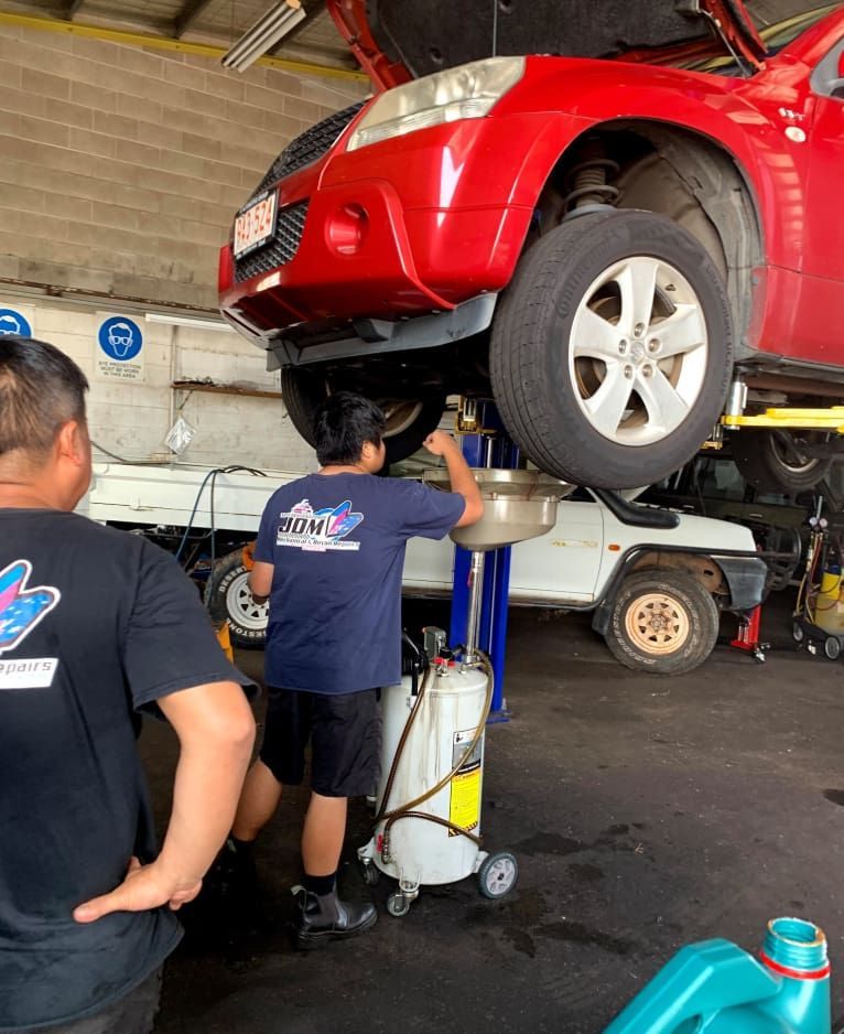 Two Men Are Working on a Red Car in a Garage — JDM Mechanical & Aircon Repairs In Coconut Grove, NT