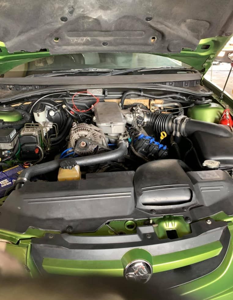 The Engine of a Green Car is Visible Under the Hood — JDM Mechanical & Aircon Repairs In Coconut Grove, NT