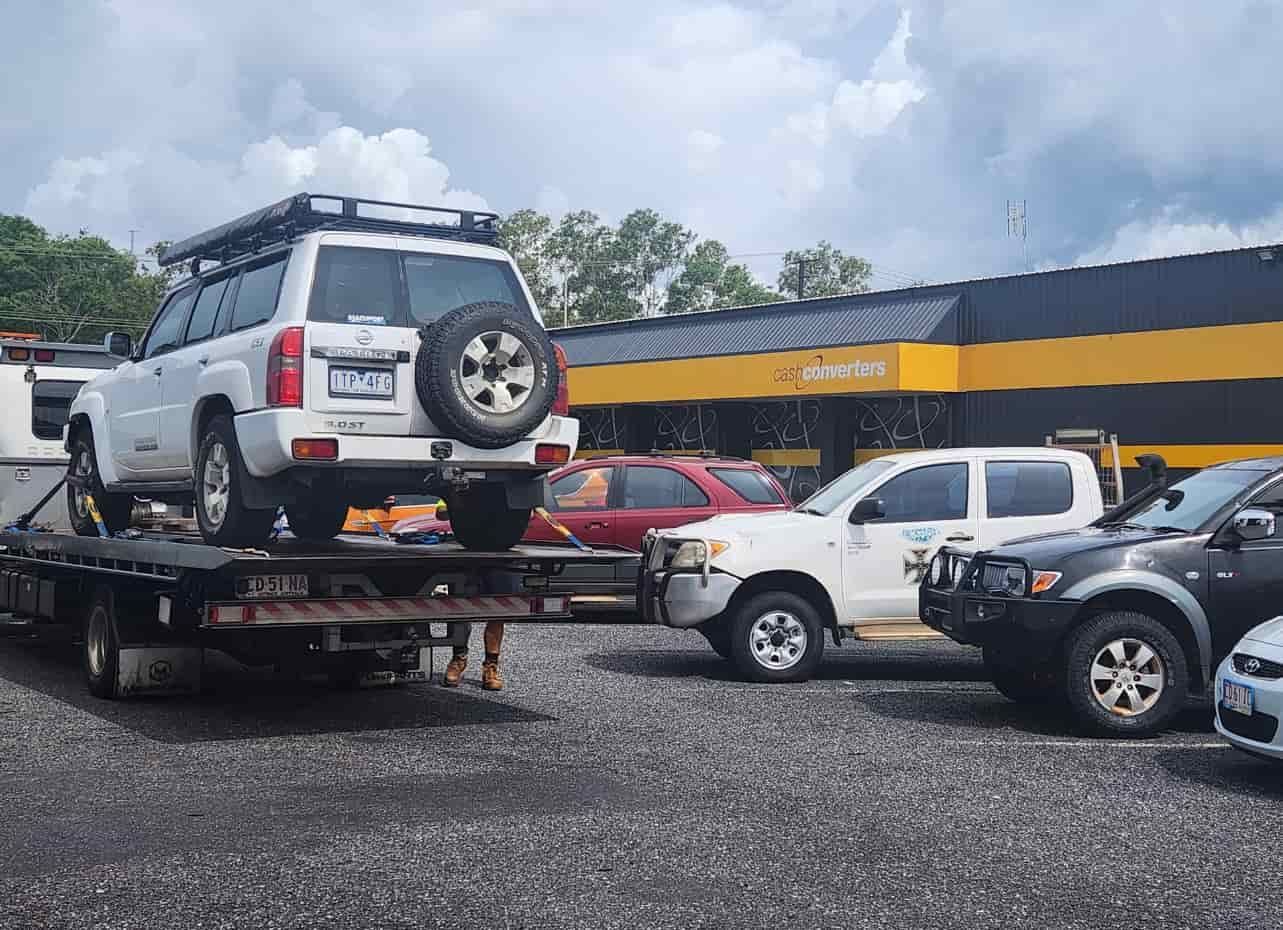 A White SUV is Being Towed by a Tow Truck — JDM Mechanical & Aircon Repairs In Coconut Grove, NT