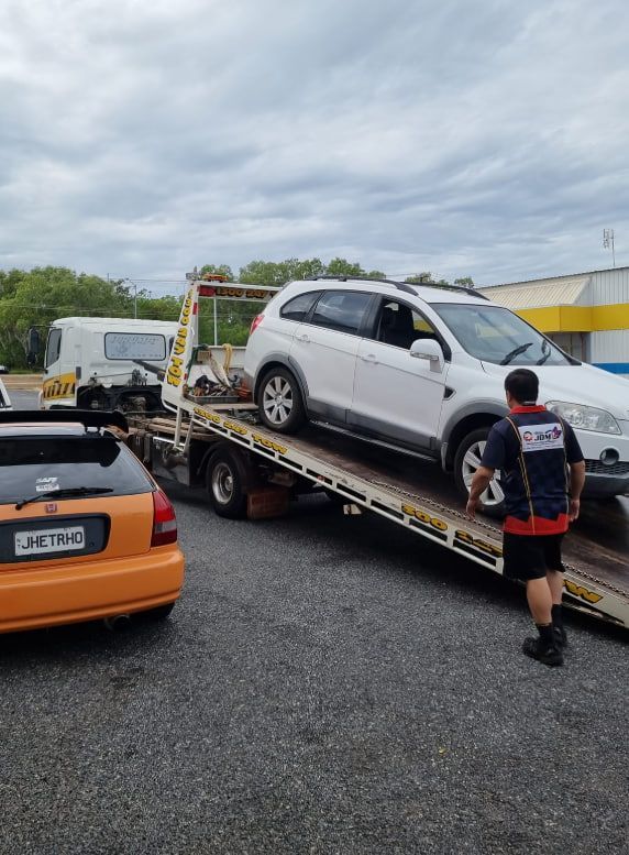 A White SUV is Being Towed by a Tow Truck — JDM Mechanical & Aircon Repairs In Coconut Grove, NT