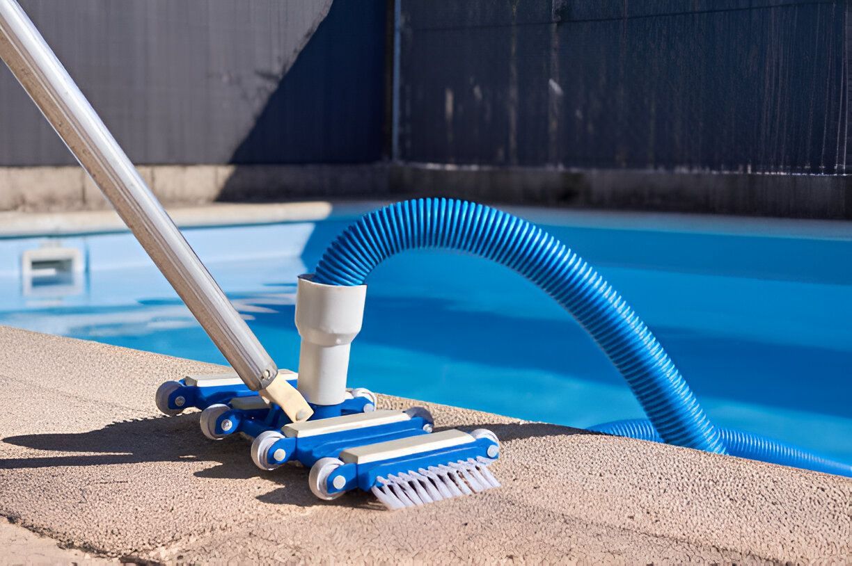 A vacuum cleaner is sitting on the edge of a swimming pool.