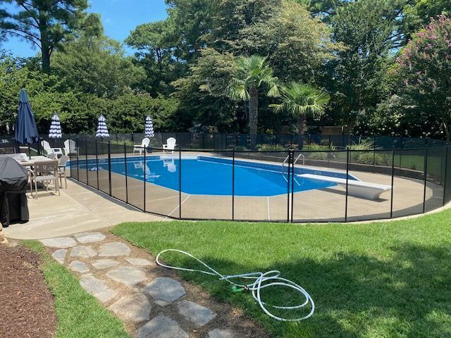 A large swimming pool with a fence around it in a backyard.