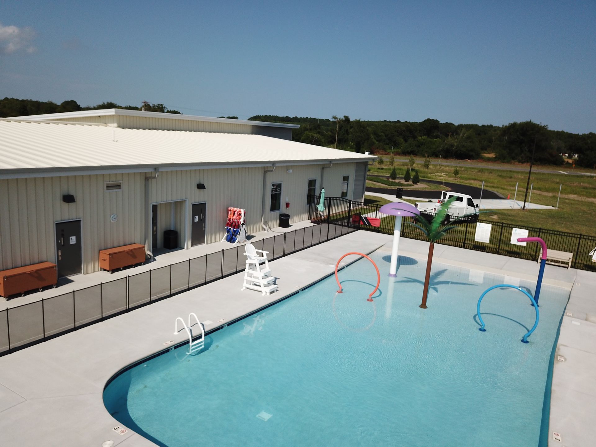 An aerial view of a large swimming pool in front of a building.