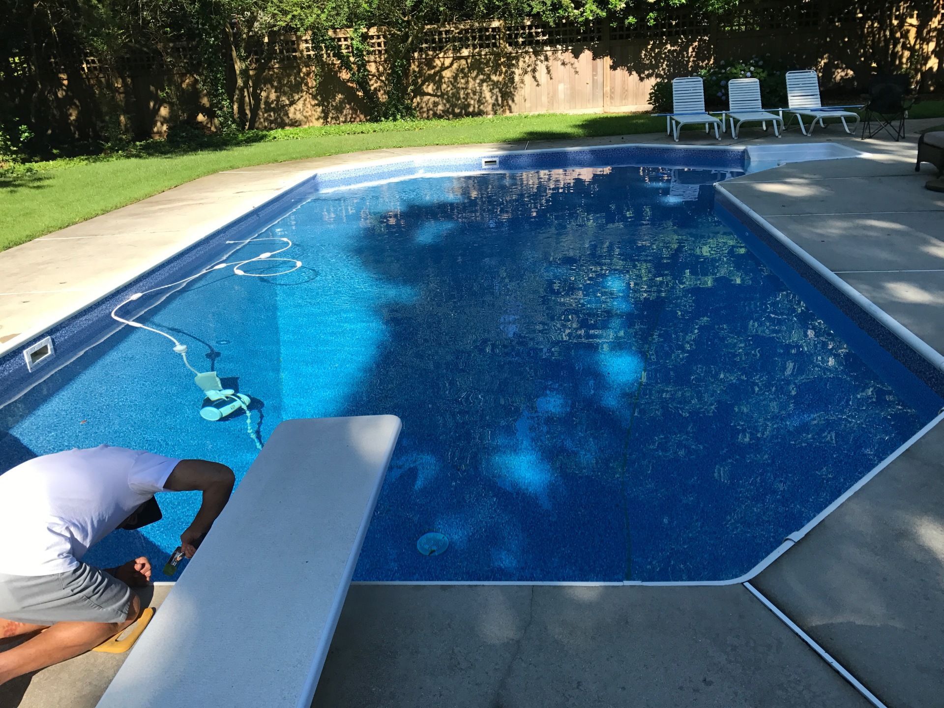 A man is working on the edge of a swimming pool